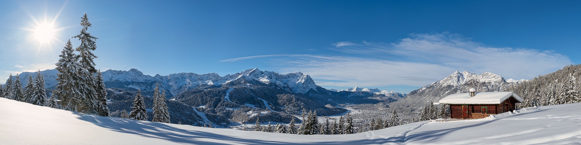 Neuschnee in Garmisch-Partenkirchen. Auf den Bäumen liegt noch der Pulverschnee, der im Sonnenlicht glitzert.