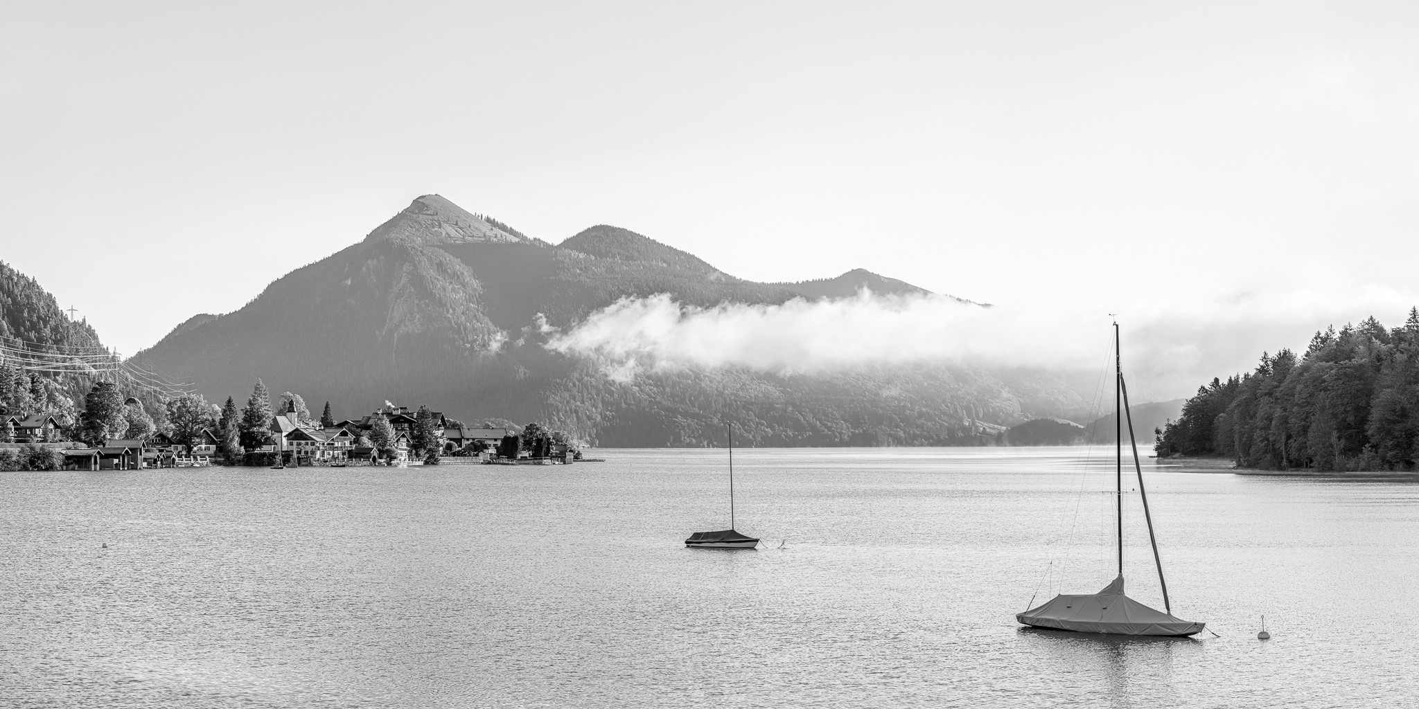 Morgenstimmung am Walchensee mit Blick auf zwei ankernde Segelboote. Im Hintergrund der Jochberg.