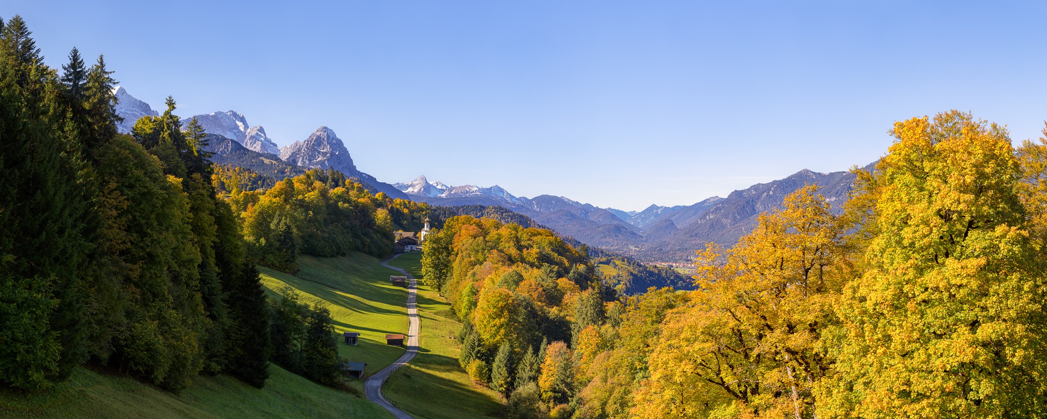 Herbststimmung am Wamberg mit Blick auf die Kirche St. Anna. Berge: Alpspitze, Zugspitze, Waxenstein und Daniel.