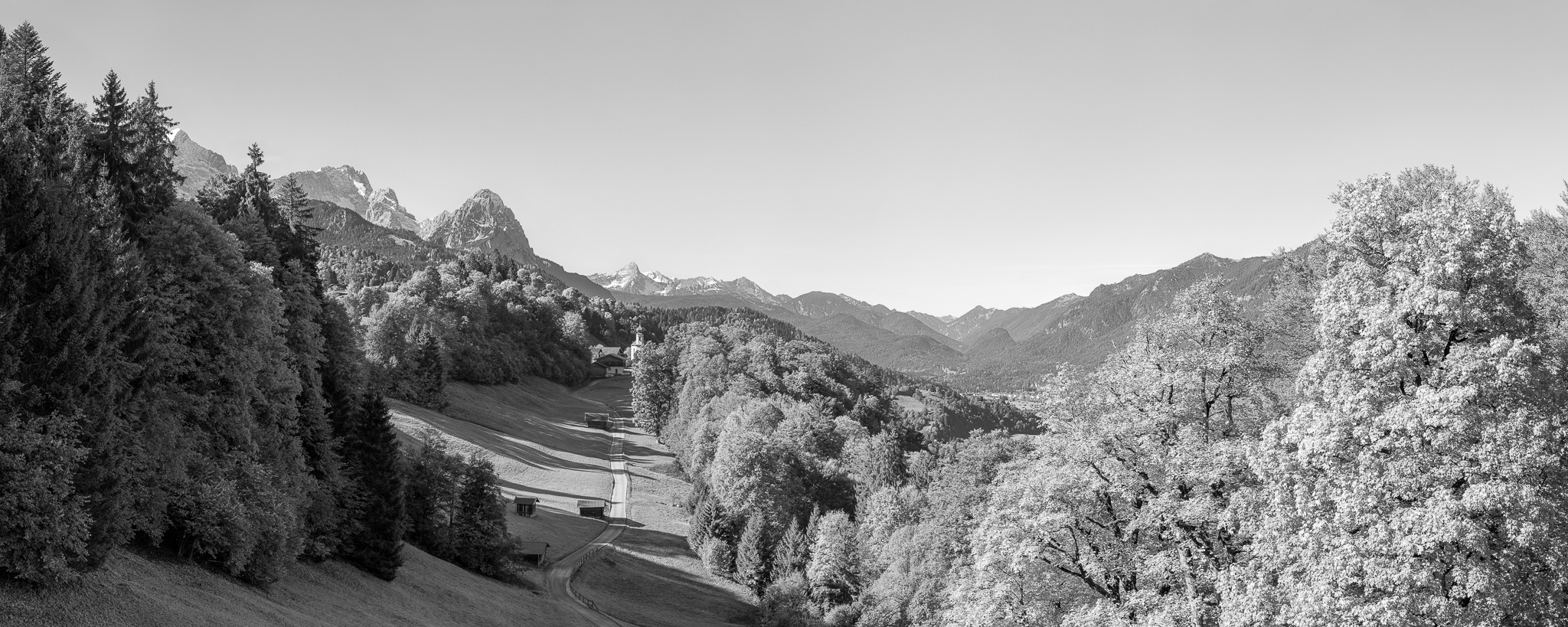 Wamberg mit Blick auf die Kirche St. Anna. Berge: Alpspitze, Zugspitze, Waxenstein und Daniel.in schwarz weiß.