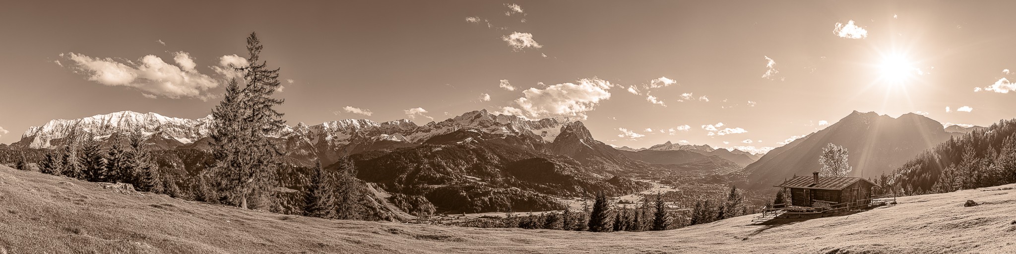 Bergpanorama mit Almhütte über Garmisch-Partenkirchen - sepia. Blick auf das Wettersteingebirge mit Alpspitze und Zugspitze und auf der rechten Seite der Kramer.