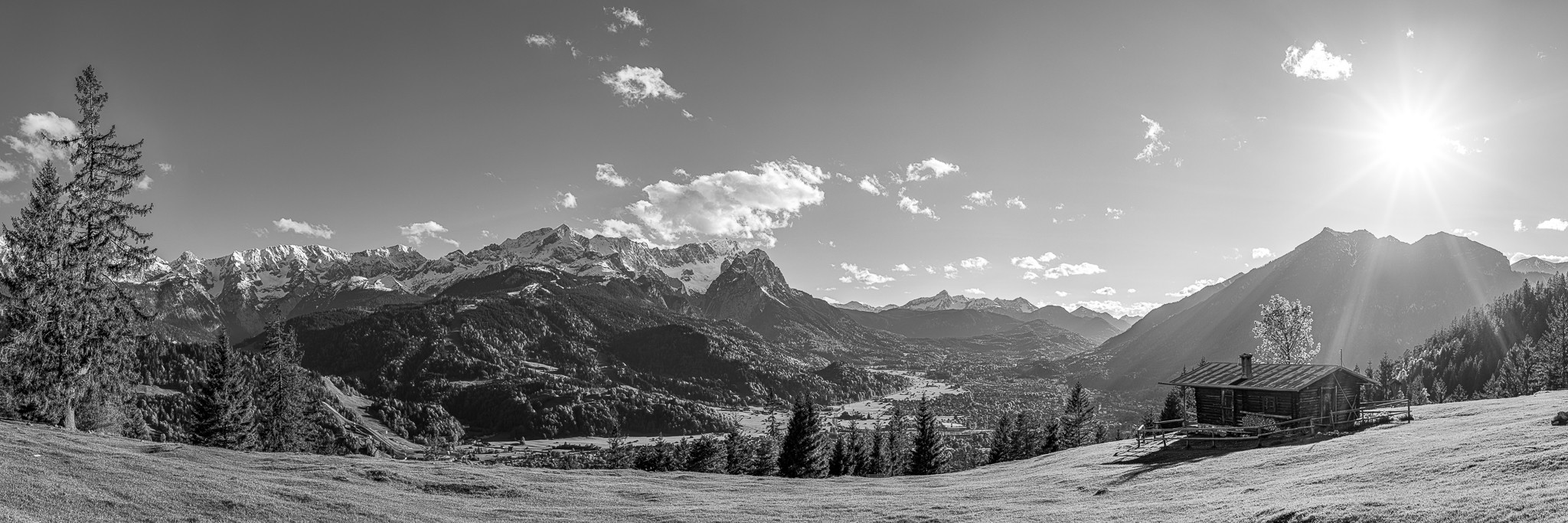 Idyllisches Bergpanorama in den bayerischen Alpen auf Garmisch-Partenkirchen und die Zugspitze mit Almhütte - schwarz-weiß