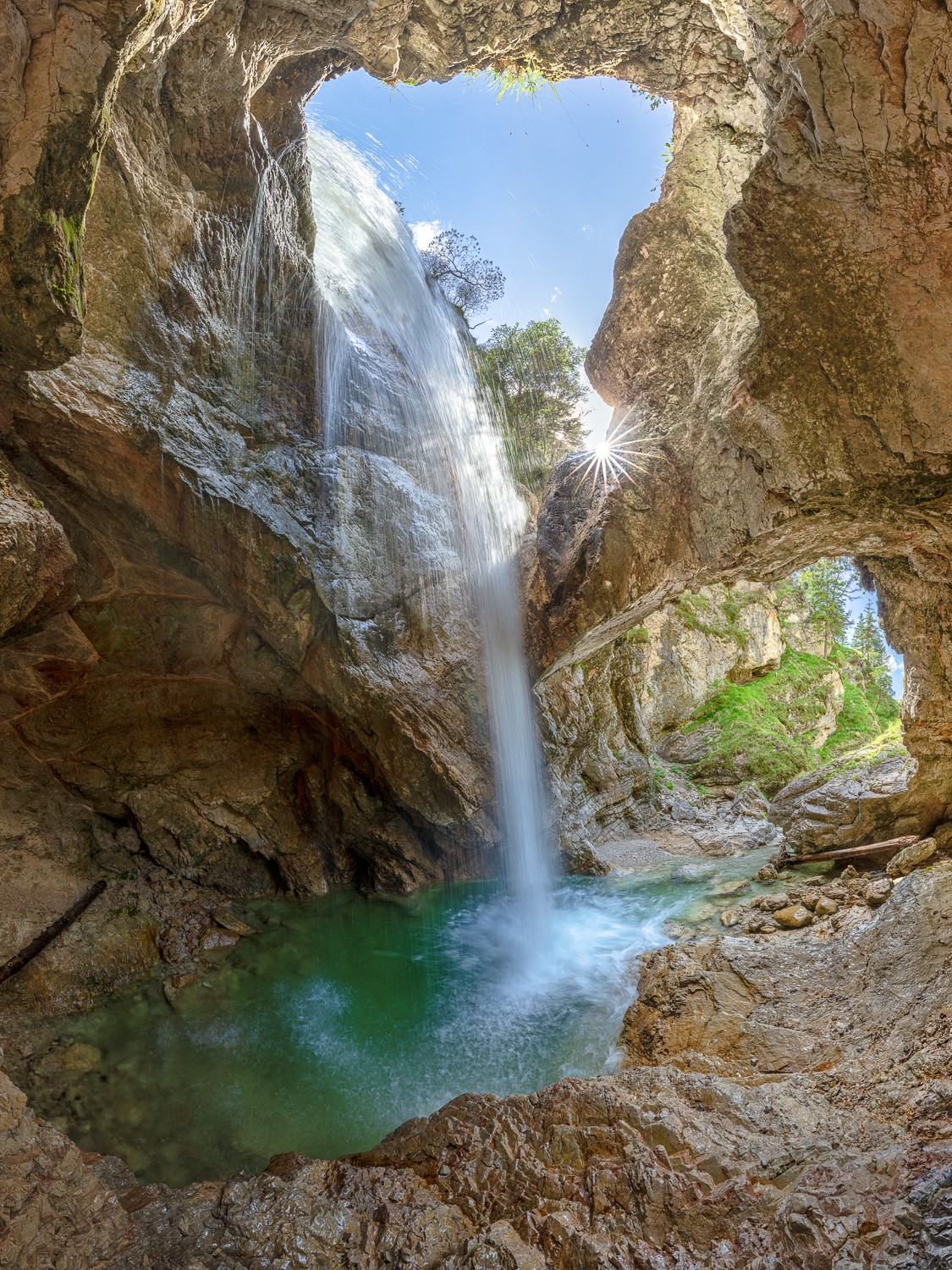 Wasserfall mit Höhle im Karwendel - hochkant. Der Wasserfall im Karwendel fällt in eine Höhle mit Ausblick.