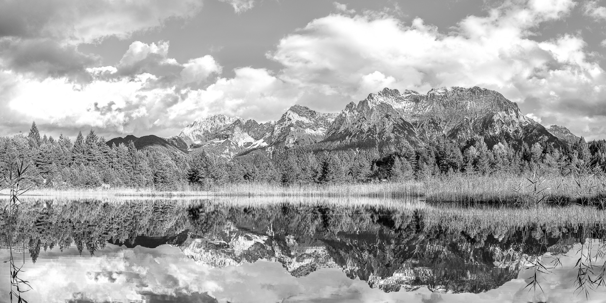 Schwarz weiß - Wolkenspiel über dem Karwendelgebirge. Der Luttensee liegt idyllisch in einer Senke oberhalb von Mittenwald. Spiegelbild vom Mittenwalder Karwendelgebirge im Luttensee.